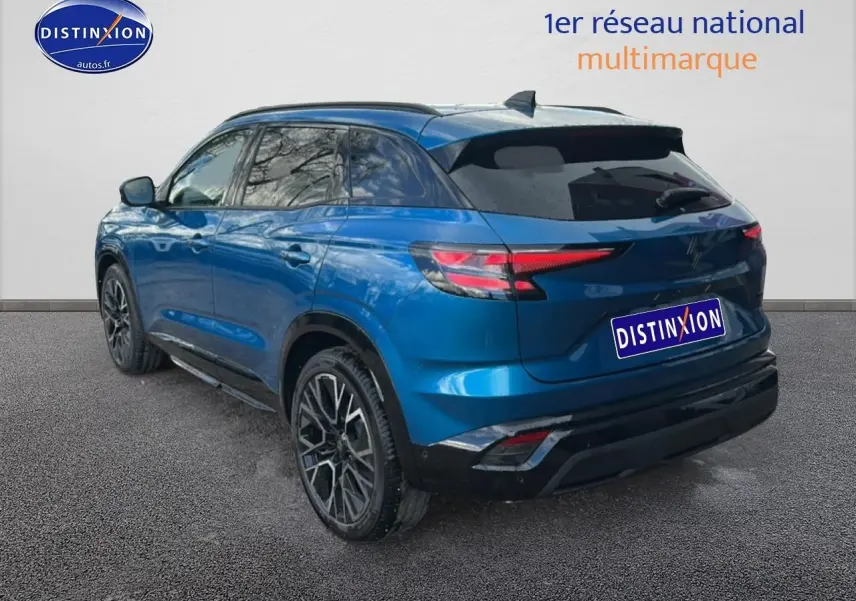 Vue 3/4 arrière droite d’un Renault Austral bleu avec jantes alliage noires et vitres teintées.