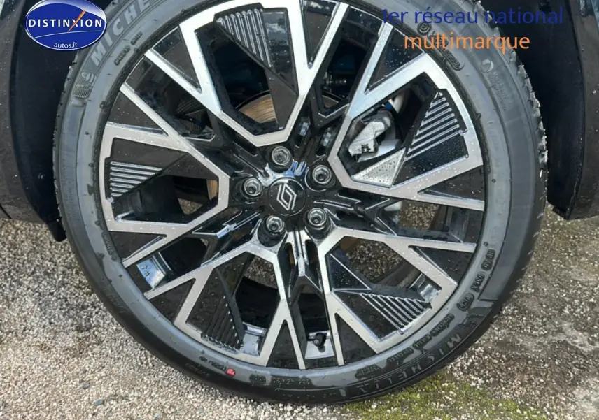 Gros plan sur la jante alliage 20 pouces noire et argentée du Renault Austral bleu, avec logo Renault au centre.