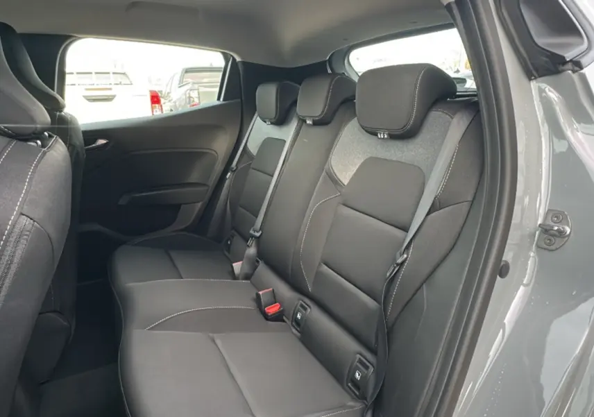 Vue intérieure côté droit sur la banquette arrière gris foncé de la Renault Clio Gris Rafale 2025, avec ceintures et appuie-têtes.