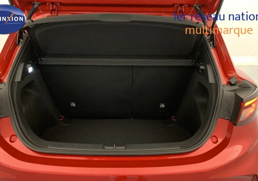 Coffre ouvert vu de l'arrière d'une MG3 1.5 Hybrid+ 195 Luxury rouge Diamond, intérieur noir spacieux et éclairé.
