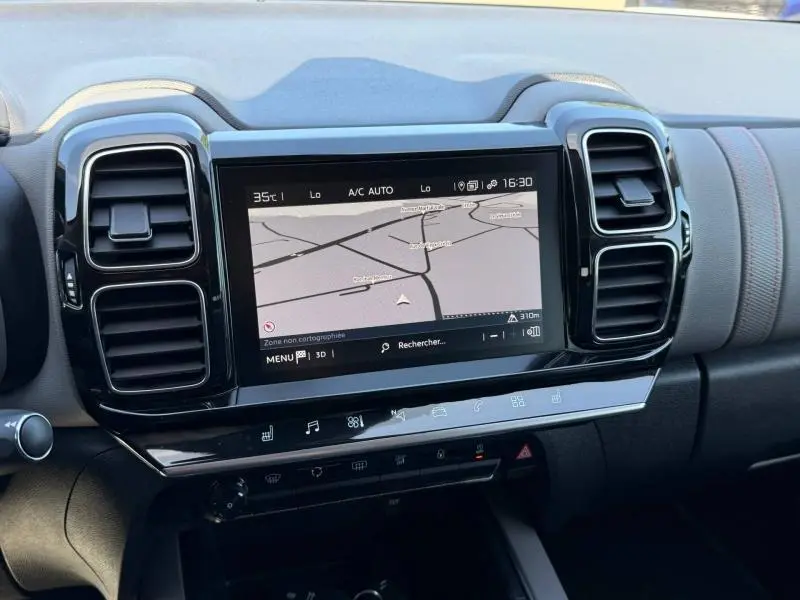 Vue rapprochée de l’écran tactile central du tableau de bord du Citroën C5 Aircross gris avec navigation et commandes climatisation.