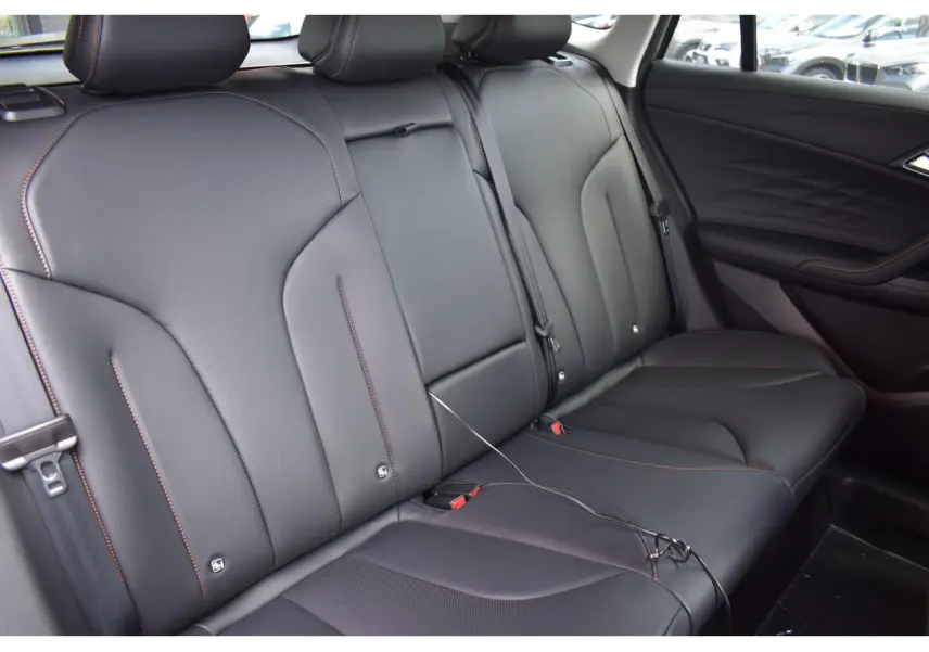 Vue intérieure sur la banquette arrière en cuir noir avec surpiqûres orange du MG Motor EHS 1.5 Hybrid+ 224 ch Luxury 2026.