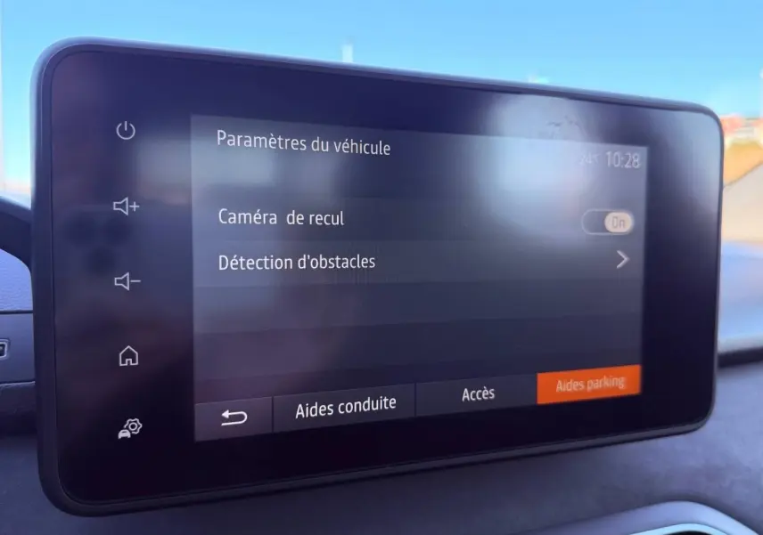 Écran tactile du tableau de bord de la Dacia Sandero 2025 affichant les paramètres de caméra de recul et détection d'obstacles.