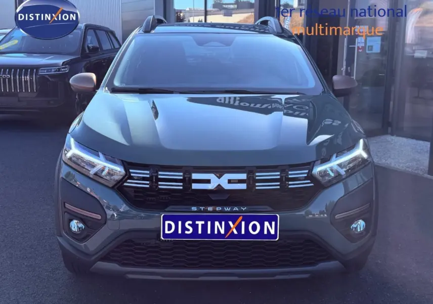 Vue frontale d'une Dacia Sandero Stepway 2025 en kaki lichen avec phares LED et calandre noire distinctive.