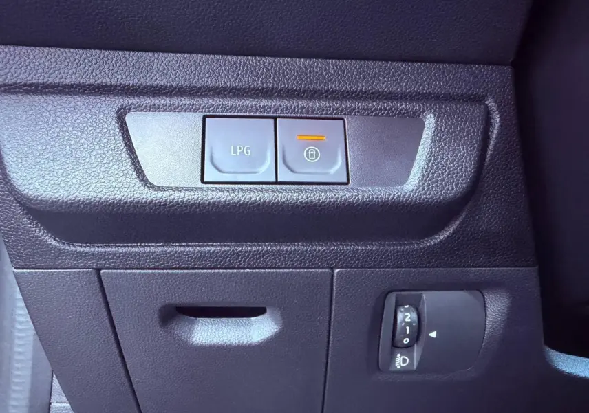 Gros plan sur les commandes intérieures noires du tableau de bord de la Dacia Sandero 2025, avec bouton LPG allumé.