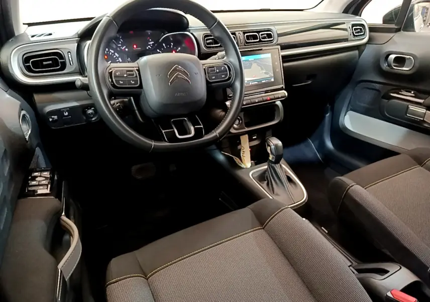Intérieur avant droit de la Citroën C3 2019 avec tableau de bord noir, volant cuir multifonctions et écran tactile central.