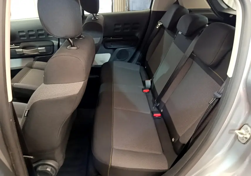 Vue intérieure côté droit montrant la banquette arrière grise et noire du Citroën C3 PureTech 2019 avec détails de couture jaune.