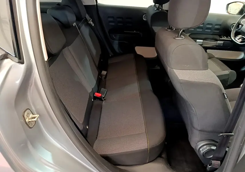 Vue intérieure côté gauche sur la banquette arrière et sièges avant d'une Citroën C3 gris clair de 2019.