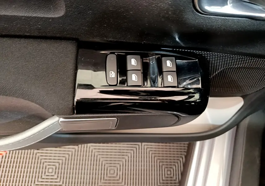 Vue rapprochée des commandes de lève-vitres sur la porte côté gauche d'une Citroën C3 gris clair de 2019.
