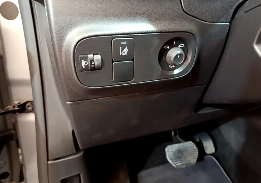 Gros plan sur les commandes de réglage des phares et rétroviseurs côté conducteur d'une Citroën C3 gris clair 2019.