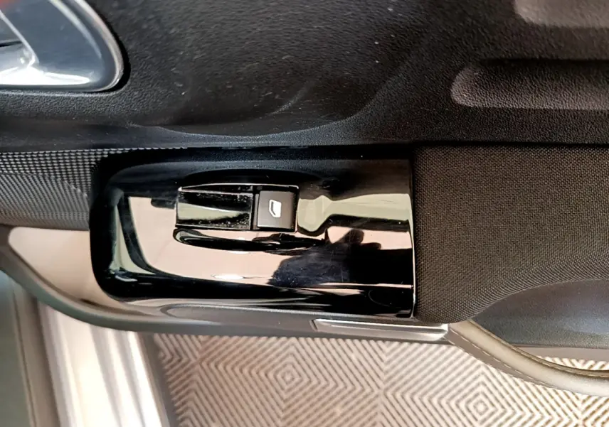 Gros plan sur le bouton de commande de la vitre côté conducteur de la Citroën C3 gris clair de 2019.