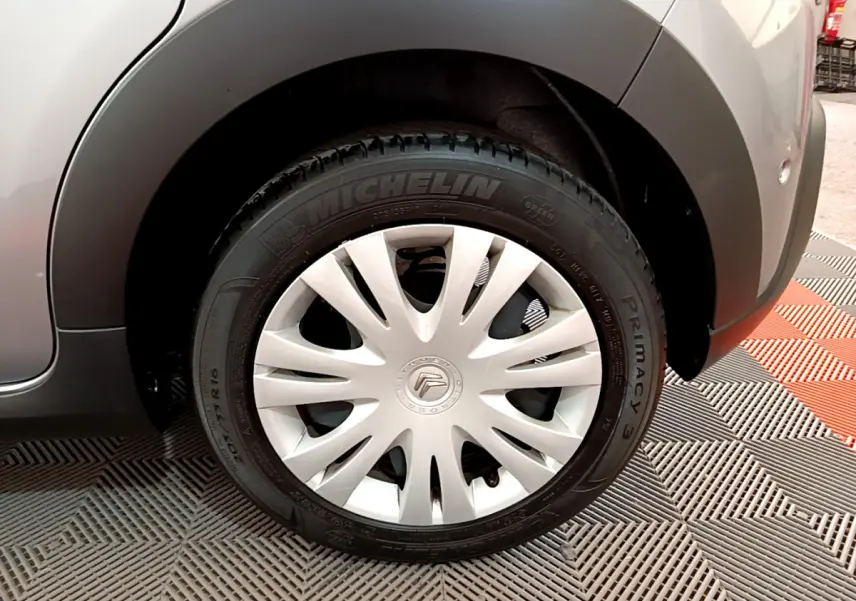 Gros plan sur la roue avant droite grise claire d'une Citroën C3 2019 avec enjoliveur blanc et pneu Michelin.