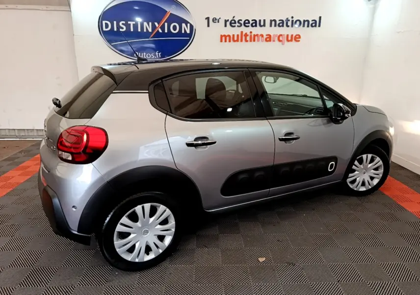 Citroën C3 gris clair vue de profil côté droit, avec toit noir et protections latérales noires distinctives.