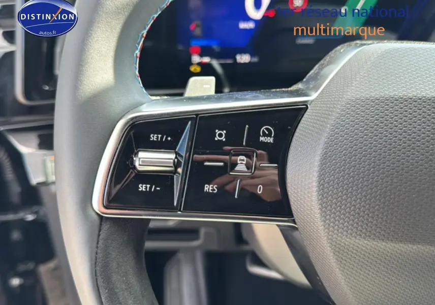 Gros plan sur le volant noir avec surpiqûres bleues du Renault Austral 2026, boutons de commande multifonction visibles.