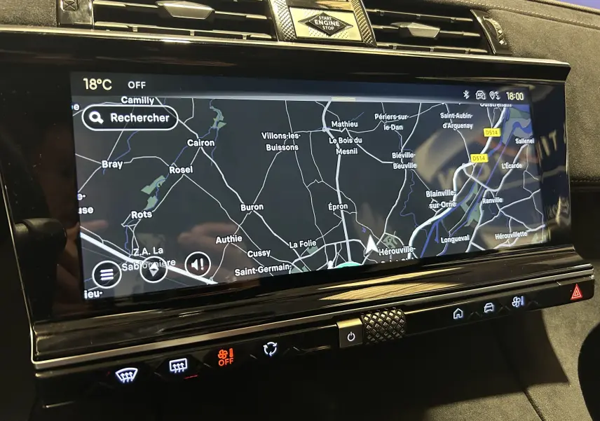 Vue rapprochée de l'écran tactile central du DS7 gris titane, affichant la carte de navigation avec commandes tactiles en dessous.