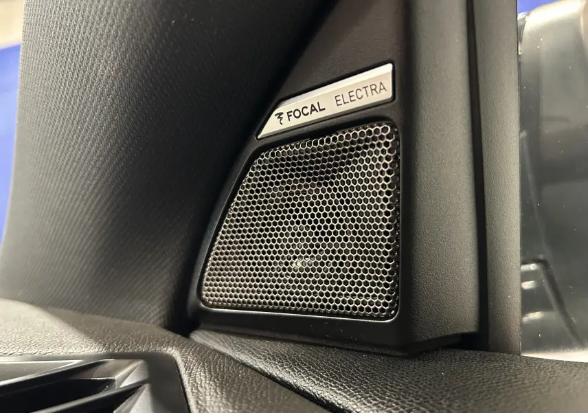 Gros plan sur l'enceinte Focal Electra intégrée à l'angle intérieur côté gauche du tableau de bord du DS7 gris titane.