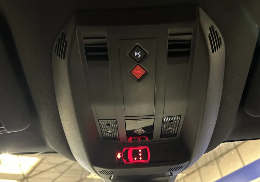 Vue intérieure en gros plan du plafonnier avec commandes SOS et éclairage du DS7 gris titane 2024.