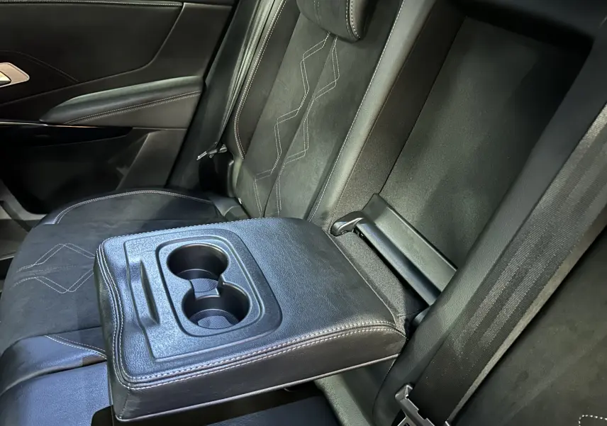Détail de l’accoudoir arrière rabattable avec porte-gobelets sur la banquette en cuir noir du DS7 Gris Titane.