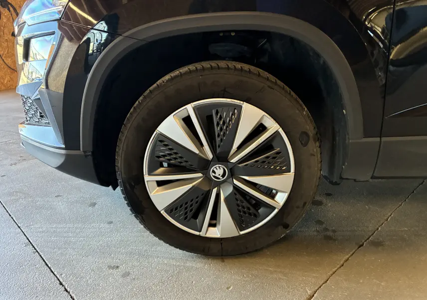 Gros plan sur la roue avant gauche noire du Skoda Karoq 2024 avec jante alliage 17'' SCUTUS et enjoliveur noir mat.