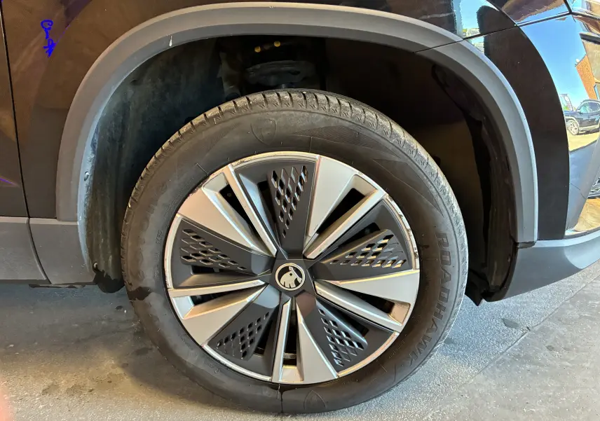 Gros plan sur la roue avant gauche noire du Skoda Karoq 2024 avec jante alliage 17'' SCUTUS et enjoliveur aéro.