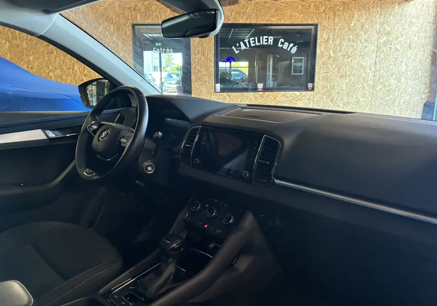 Intérieur noir du Skoda Karoq 2024 vu côté conducteur, avec tableau de bord épuré et volant multifonctions.