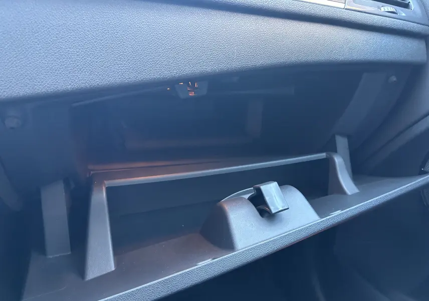 Gant de rangement ouvert côté passager intérieur d'un Skoda Karoq noir, montrant la texture du tableau de bord.
