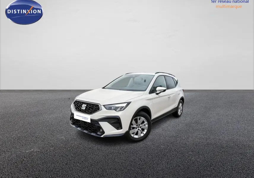 SEAT Arona blanc vue 3/4 avant droit sur sol gris, avec calandre noire et jantes alliage 16 pouces design.