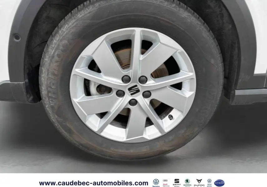 Gros plan sur la roue avant droite blanche d’une SEAT Arona 2026 avec jante alliage 16 pouces design.