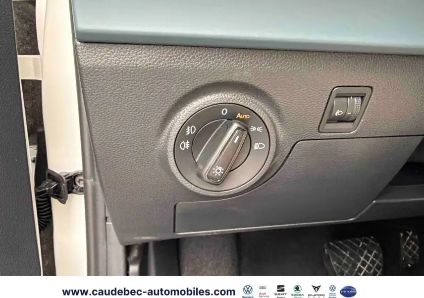 Détail du panneau de commande des phares sur la gauche du tableau de bord d’un SEAT Arona blanc.