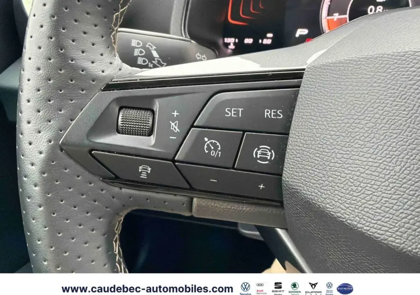 Gros plan sur les commandes du volant en cuir perforé du SEAT Arona, avec boutons de régulateur adaptatif et assistance au maintien de voie.