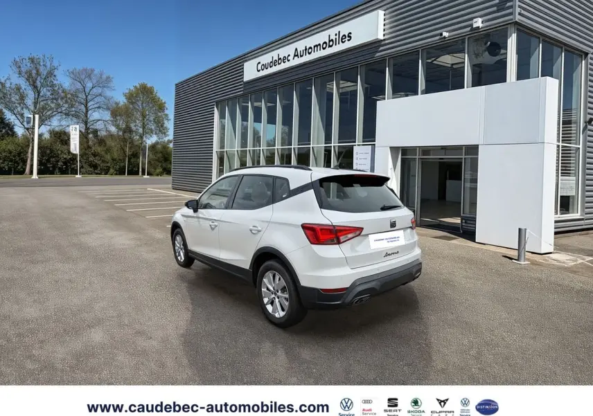 SEAT Arona blanche vue 3/4 arrière droit devant concession Coudebec Automobiles, jantes alliage 16 pouces.