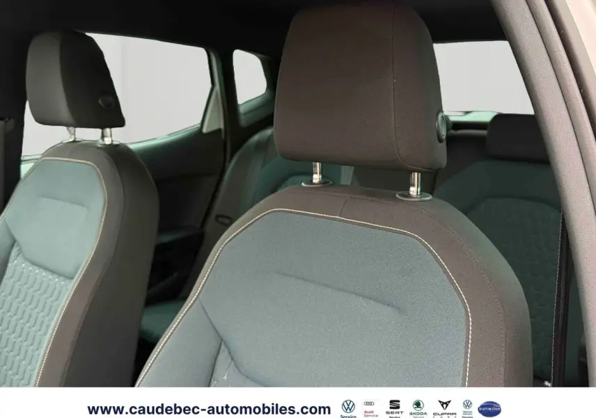 Gros plan sur les sièges avant en tissu gris et noir du SEAT Arona blanc, vue intérieure côté conducteur.