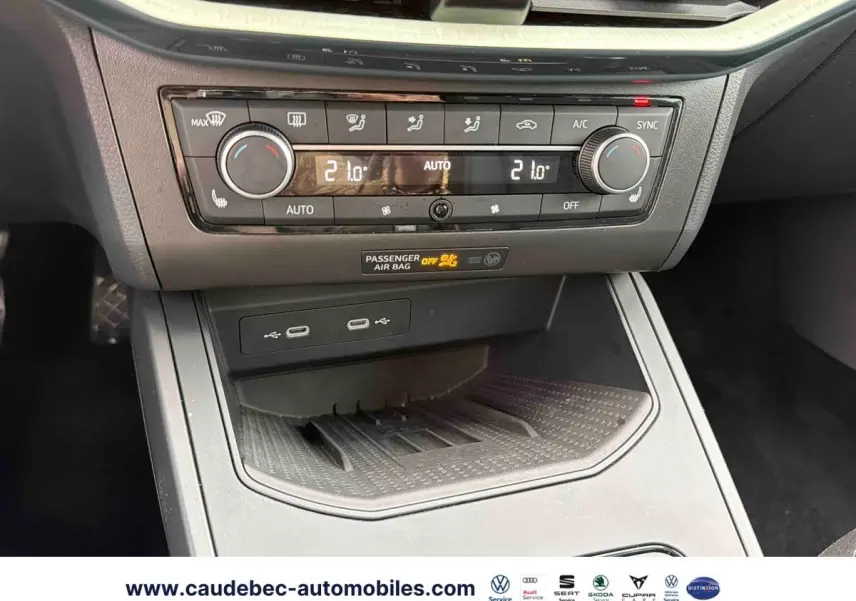 Vue rapprochée de la console centrale avec commandes de climatisation automatique et ports USB du SEAT Arona blanc.