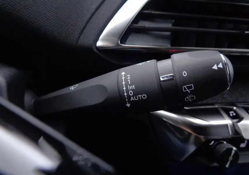Gros plan sur la commande d'essuie-glace à gauche du volant dans l'habitacle du Peugeot 3008 bleu Celebes 2023.