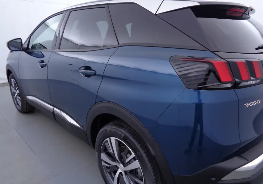 Vue 3/4 arrière droite d'un Peugeot 3008 bleu Celebes métallisé avec feux arrière à griffes rouges distinctifs.