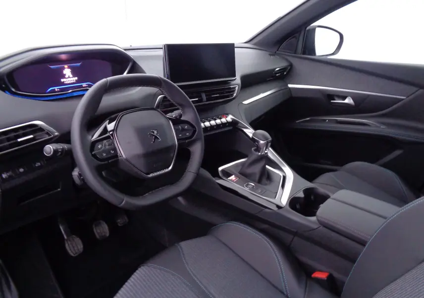 Intérieur avant droit du Peugeot 3008 2023, volant compact, écran tactile central et sièges tissu noir avec surpiqûres bleues.