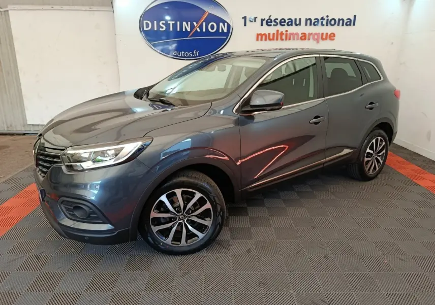 Renault Kadjar Business gris foncé vu en 3/4 avant droit, avec jantes alliage et feux LED dans un showroom.