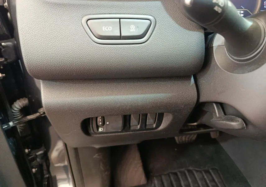 Vue intérieure côté gauche du tableau de bord du Renault Kadjar 2022, boutons Eco et réglage phares visibles.