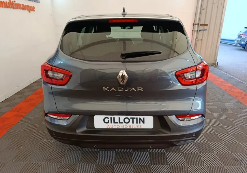 Vue arrière d'un Renault Kadjar gris foncé 2022 avec feux rouges et logo chromé bien visibles.