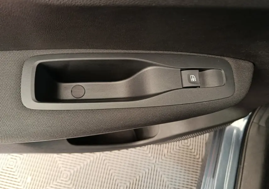 Poignée intérieure côté gauche avec bouton de commande de vitre sur porte d'un Renault Kadjar gris foncé 2022.