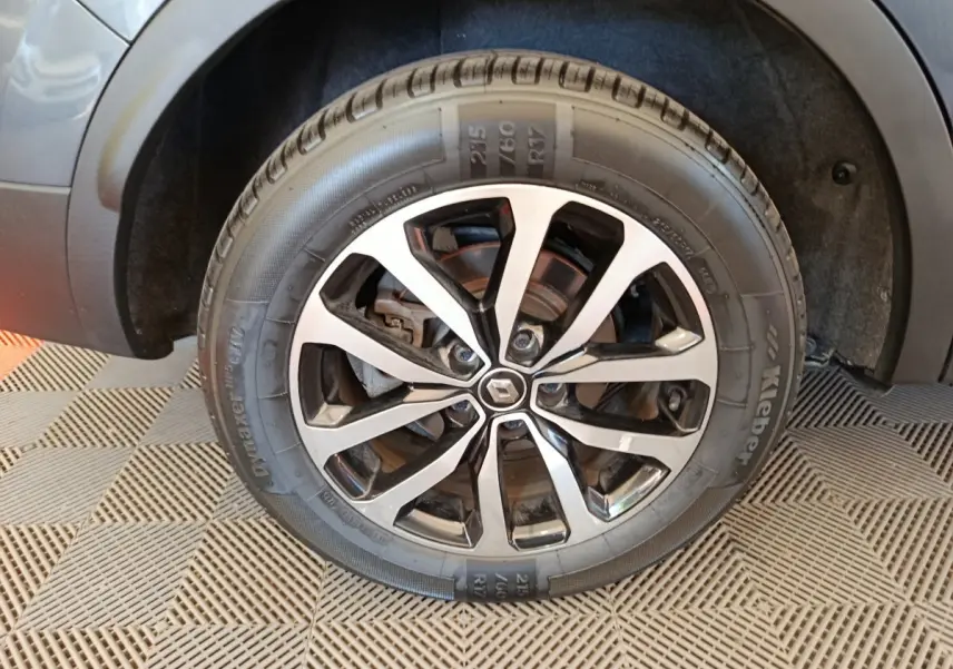 Gros plan sur la roue avant droite du Renault Kadjar gris foncé, mettant en valeur la jante alliage au design moderne.