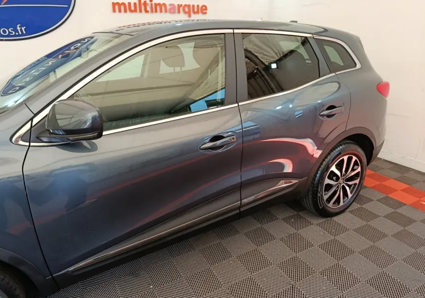 Profil côté gauche du Renault Kadjar gris foncé 2022 avec jantes alliage et rétroviseurs électriques chromés.