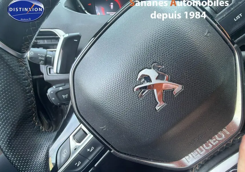 Gros plan sur le volant cuir perforé noir du Peugeot 3008 GT Pack Black, avec logo lion chromé au centre.