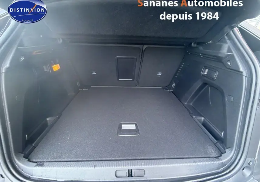 Coffre ouvert vu de l'arrière d'un Peugeot 3008 gris foncé avec intérieur noir et banquette rabattable.