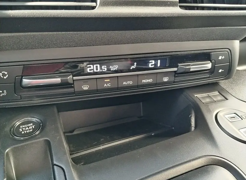 Détail de la console centrale du Peugeot Rifter 2025, affichage digital de la climatisation et bouton start/stop visible.