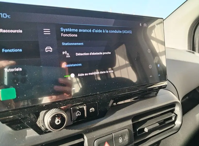 Écran tactile du système d’aide à la conduite sur tableau de bord intérieur du Peugeot Rifter vert Srikka, vue de côté droit.