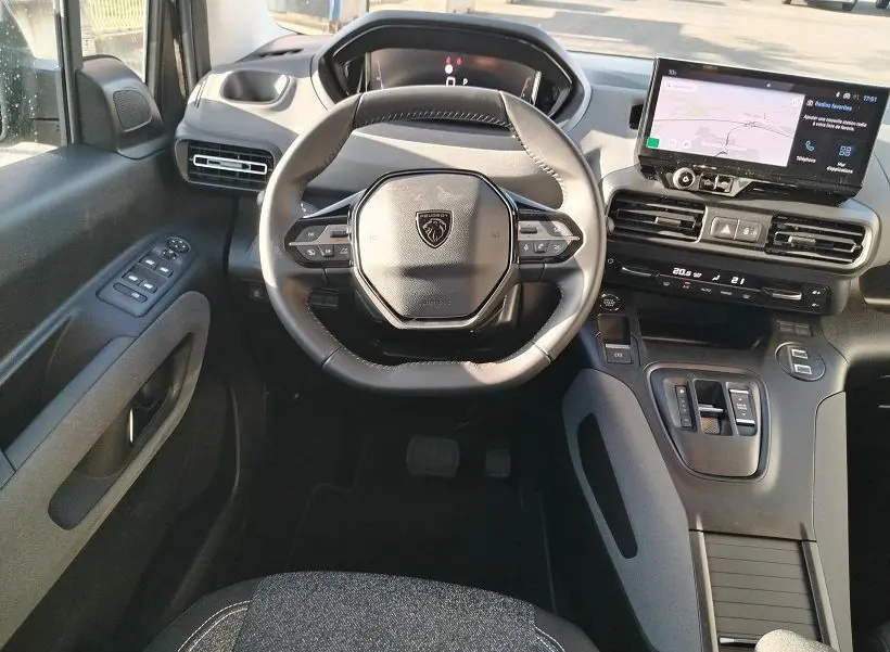 Vue intérieure frontale du poste de conduite du Peugeot Rifter 2025, avec volant compact et écran tactile central.