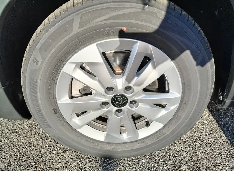 Gros plan sur la roue avant droite du Peugeot Rifter 2025 en Srikka Green, avec jante alliage argentée et logo Peugeot.