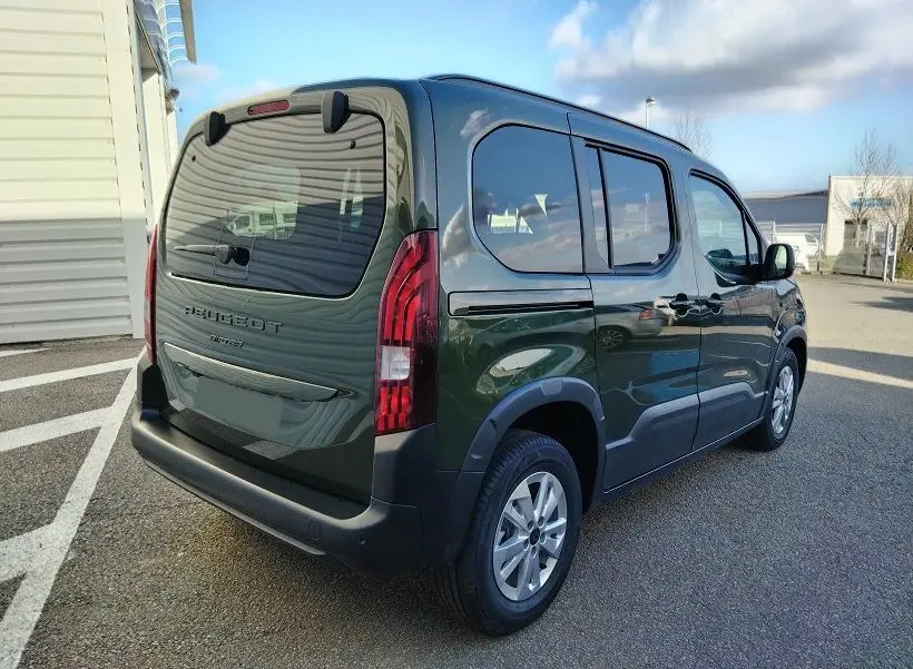 Vue 3/4 arrière droit d'un Peugeot Rifter 2025 vert Srikka avec hayon et vitres teintées.
