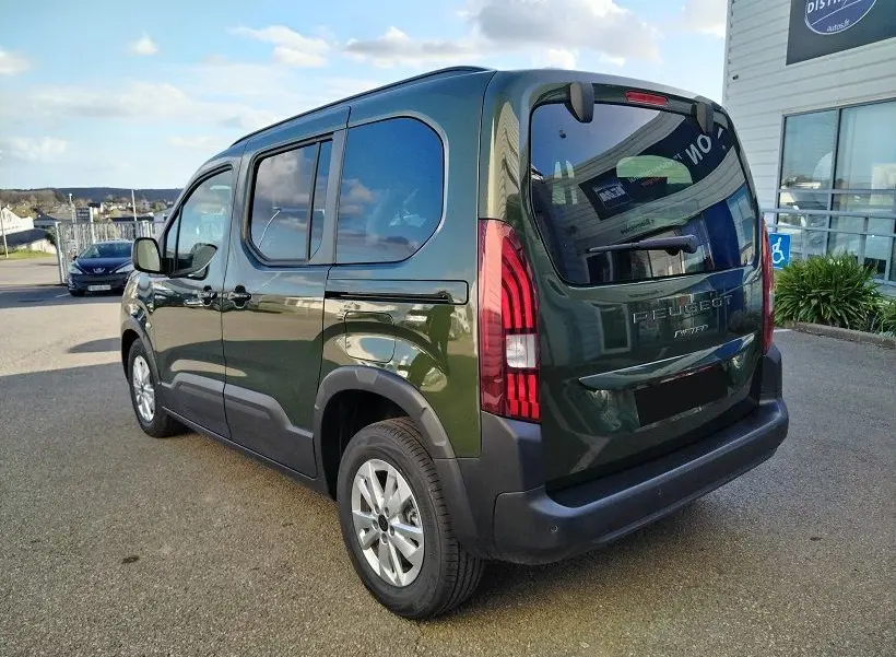 Vue 3/4 arrière droite d'un Peugeot Rifter 2025 vert Srikka avec feux arrière LED et hayon vitré.